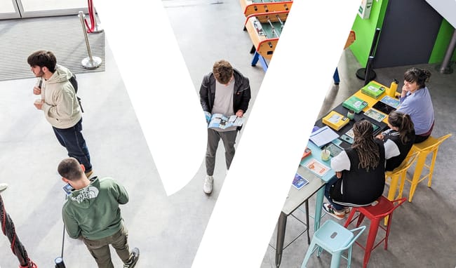 Image comprenant une salle d'études, des étudiants assis, debout. Un grand  Y  de  YNOV  fais